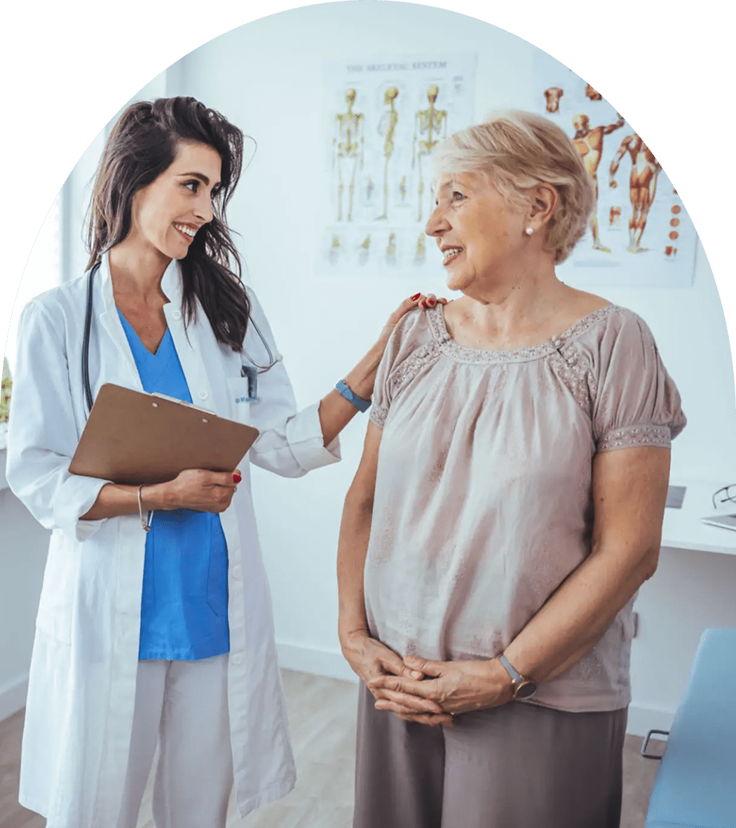 Doctor comforting elderly female patient in clinic